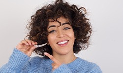 woman holding Invisalign aligner