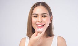 woman holding Invisalign aligner