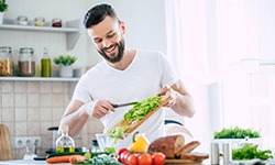 Smiling man preparing meal in kitchen at home