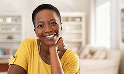 Woman in yellow shirt smiling at home