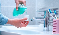 a person preparing to rinse their mouth with mouthwash