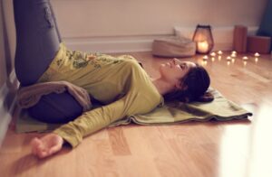 Woman doing yoga in cozy room with candles 