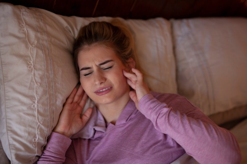 woman experiencing pain from teeth grinding