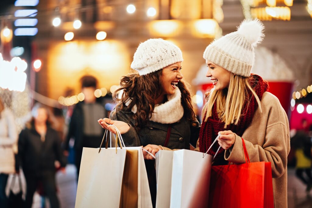 Two friends smiling while holiday shopping